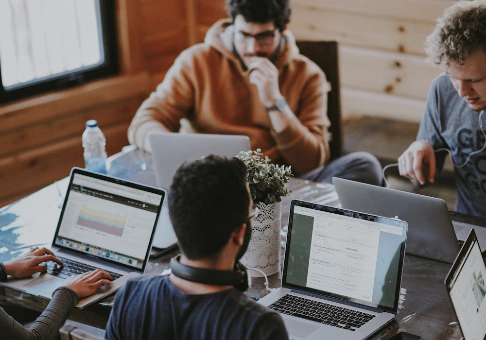 A team working together on laptops around a shared table